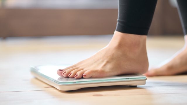 woman stepping on scale