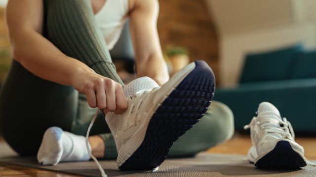 Close up of a woman putting on or taking off shoes in her home