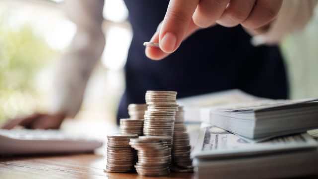 Business women put coin stack money and many bank note in office, Save money for future and Retirement.