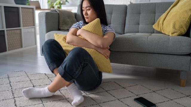 Girl Sitting Alone Holding a Pillow