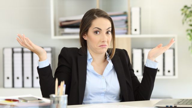 Young Woman Shrugging in Office