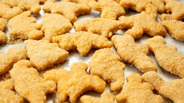 A view of a baking tray of dinosaur chicken nuggets.