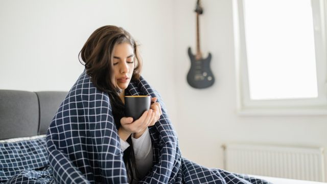 Sick woman lying in bed with high fever. Cold flu and migraine