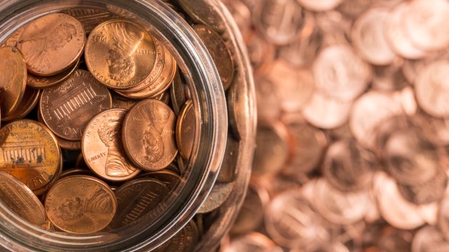 A jar of pennies surrounded by pennies.