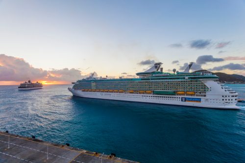 A Royal Caribbean cruise ship leaving port at dusk. 