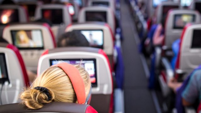 woman sitting in aisle seat on large airplane