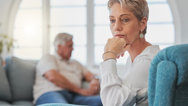 Unhappy senior couple on couch fighting or having an argument