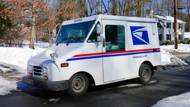 PRINCETON, NJ -10 FEB 2021- Winter view of a delivery truck from the United States Postal Service (USPS) on the street in New Jersey, United States after a snowfall.