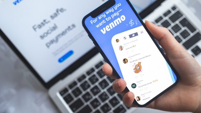 Poltava, Ukraine - April 5, 2022: Woman use Venmo app. Mobile phone banking and investment concept photo