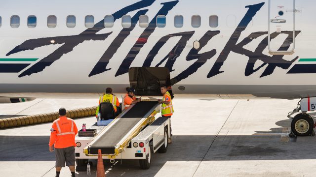 A group of Alaska Airlines baggage handlers taking a break mid day on the tarmac at the Honolulu airport.