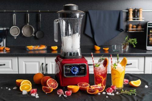 Modern electronic red blender with glasses of fresh juice