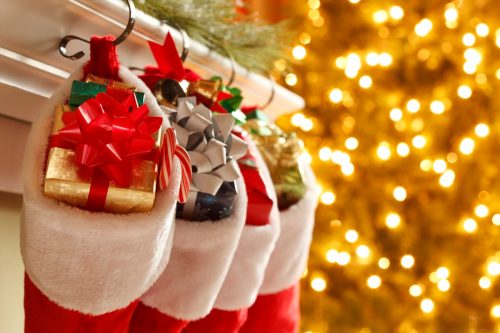 Christmas stockings in front of a blurred Christmas tree.