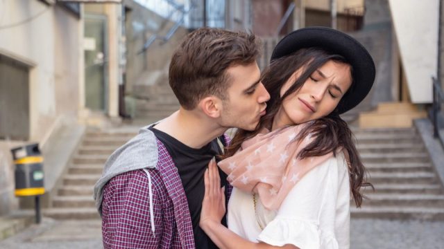 a demisexual woman pushing away a youngman trying to kiss her
