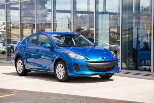 Blue Mazda 3 outside car dealership