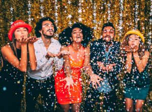 Friends blowing confetti at a new year's party.