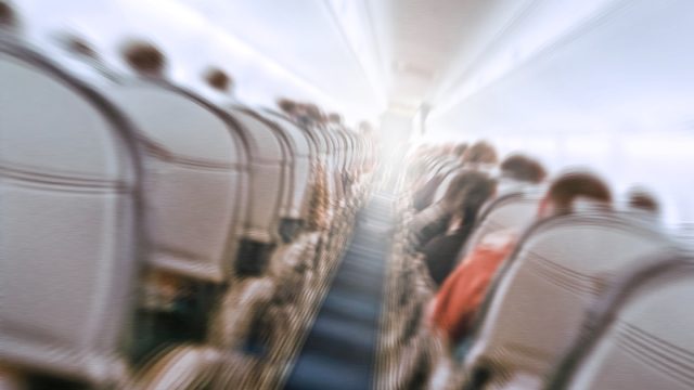 Blurry image of an airplane interior tilted, to show the concept of turbulence.