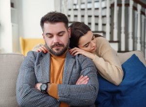 Clingy woman apologizing to boyfriend or husband