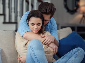 Young couple with man apologizing after fight or cheating.