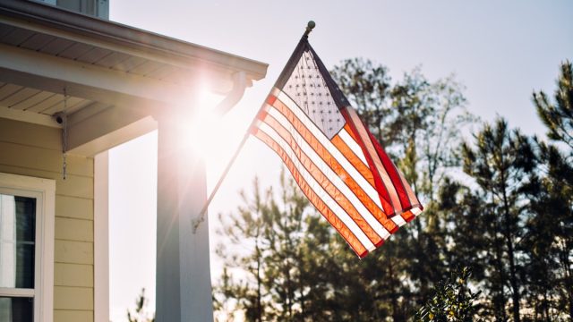 american flag flying outside of typical home