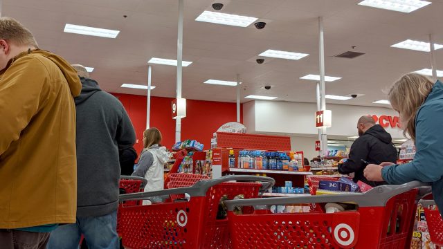 A line of customers with shopping carts at a Target store.