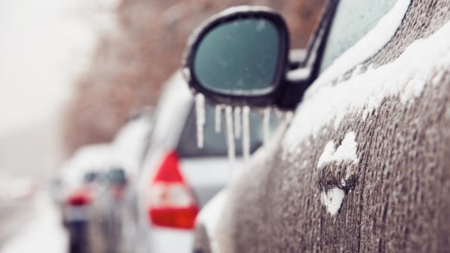 Car on the street covered by icy rain