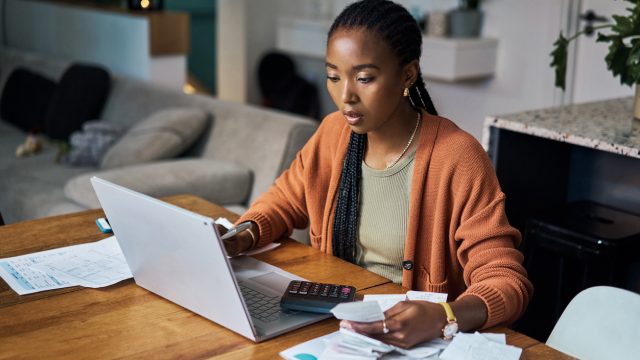 A woman sitting at a laptop while budgeting or filing taxes