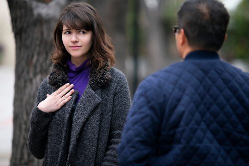Woman on the street looking skeptically at a man