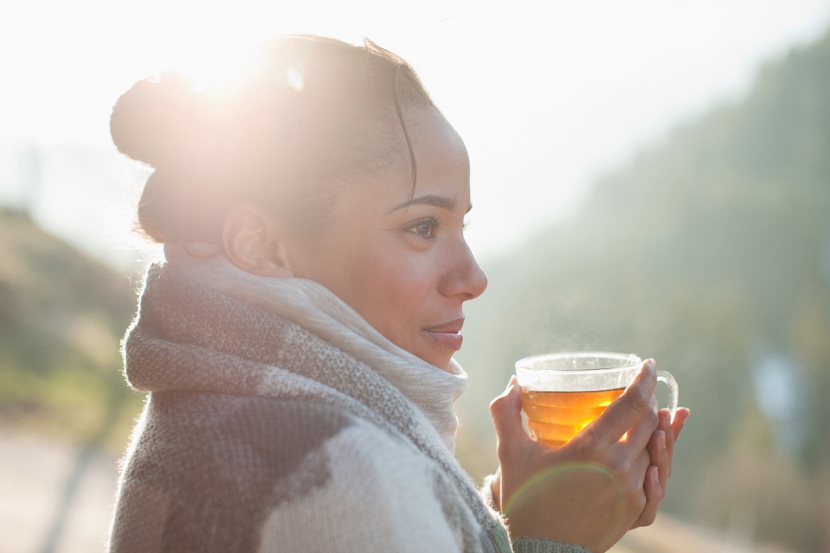 Close up of smiling woman drinking tea outdoors