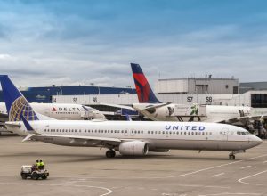 Two Delta planes at the gate while a United plane taxis behind them