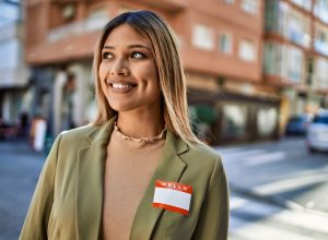 Young woman smiling on the street while wearing her name badge