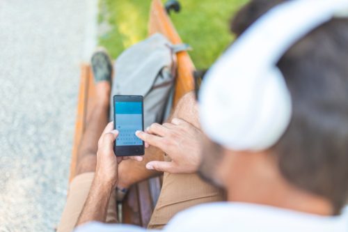 Man using cellphone on a bench in the park