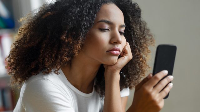 woman disappointed looking at phone