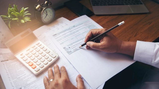 Budget planning concept,Accountant is calculating company's annual tax.Calendar 2020 and personal income tax forms for those who have income under US law placed on office desk.This is the season to pay taxes.