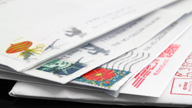 Close up of a stack of old, us letters with postage stamps.