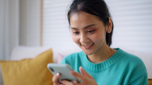woman smiling while on her phone