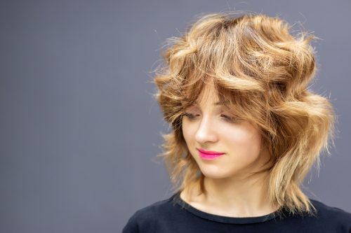 woman with thick blonde hair sporting a wolf cut