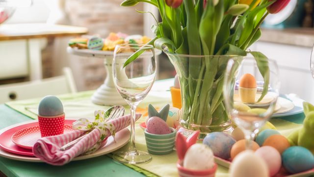 Colorful decorated Easter Place Setting with Easter Eggs, flowers on the table