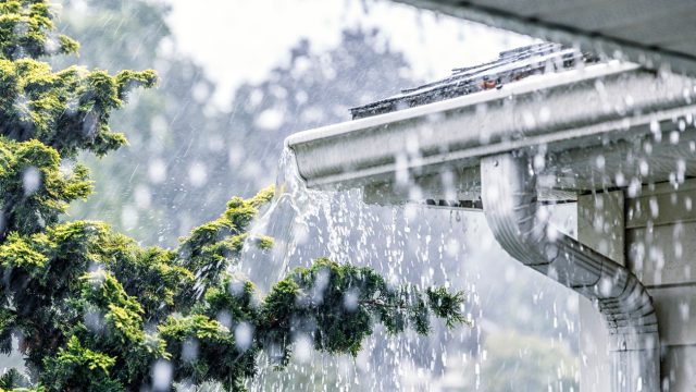Gutters on a house overflowing during a torrential rain storm