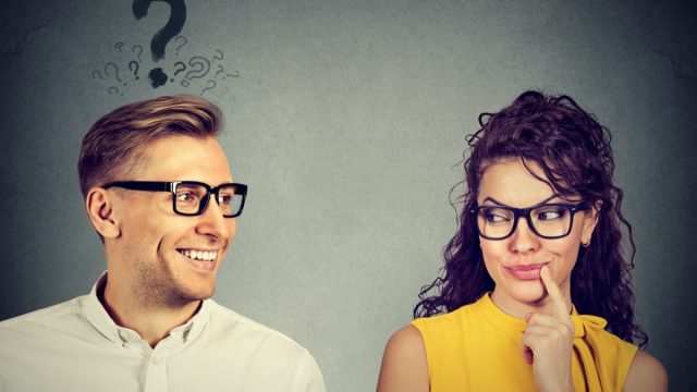 man looking at woman with question mark over his hed