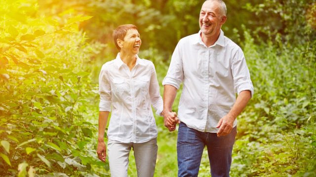 Happy senior couple taking a walk in summer in a forest