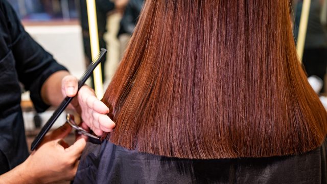 Closeup image of Hairdresser's hands cutting cowboy copper hair