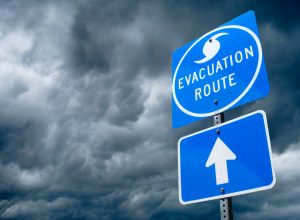A close up of a hurricane evacuation route road sign with storm clouds in the background