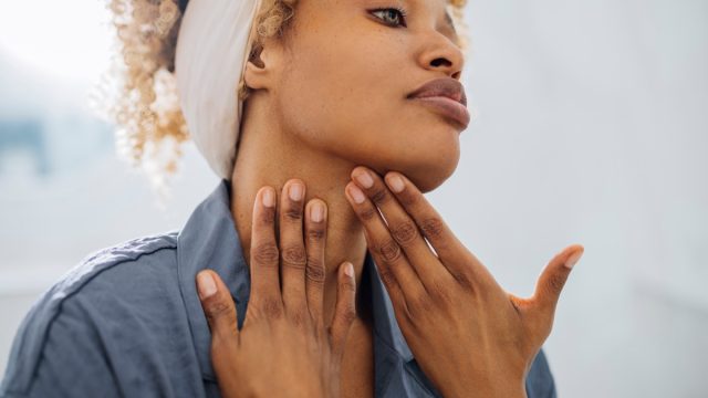 woman smoothing skin in the mirror