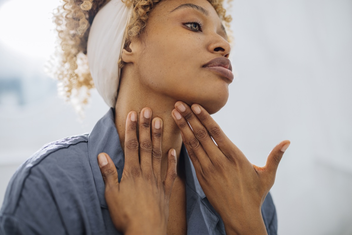 woman smoothing skin in the mirror