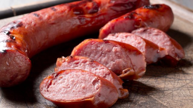 A close up of sliced pieces of turkey kielbasa sausage on a cutting board