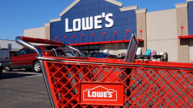 Lowe's shopping cart in parking lot with storefront in the background