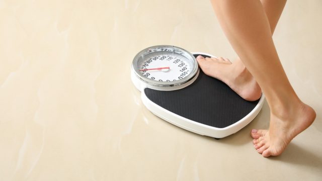 woman stepping on scale