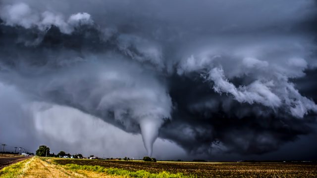 A tornado in a field surrounded by dark clouds