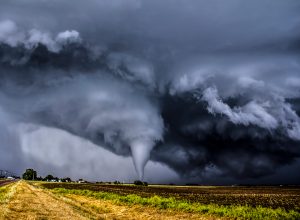 A tornado in a field surrounded by dark clouds