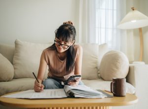 A woman sitting on her couch while preparing her finances or tax filing